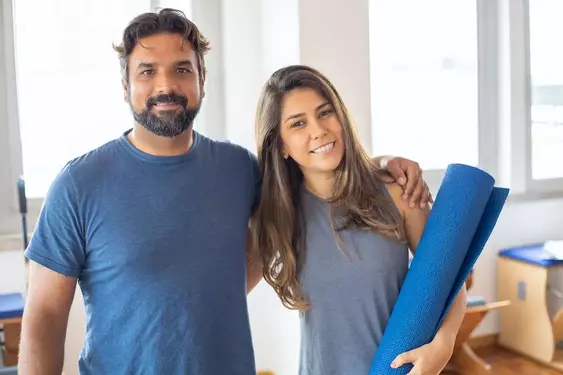 Physiotherapist and patient smiling together at the camera