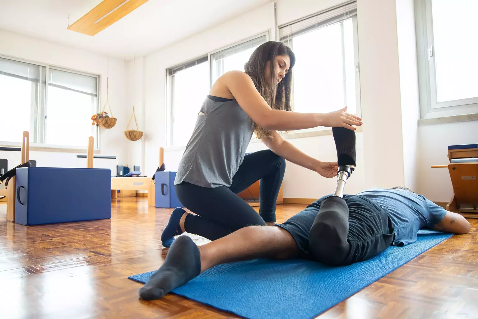 Man lying on his front, receiving treatment from a female physiotherapist