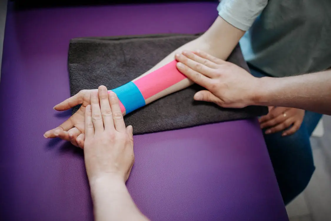 A forarem bound with kinesio tape being treated